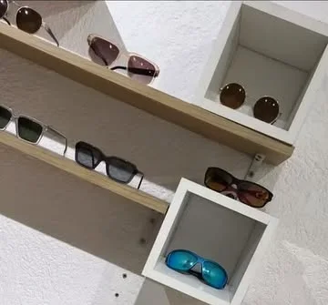 Estantes de madera con lentes de sol de distintos modelos.
